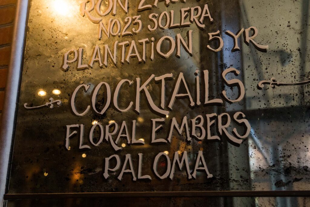 cocktail menu on a mirror on the wall in the Green Valley Grill in O.Henry Hotel in Greensboro