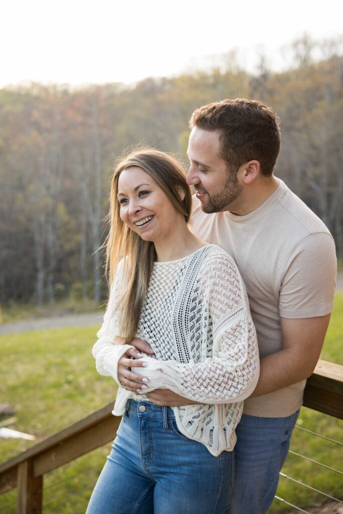 couple embraces in the golden hour light in the mountains of nc at their airbnb