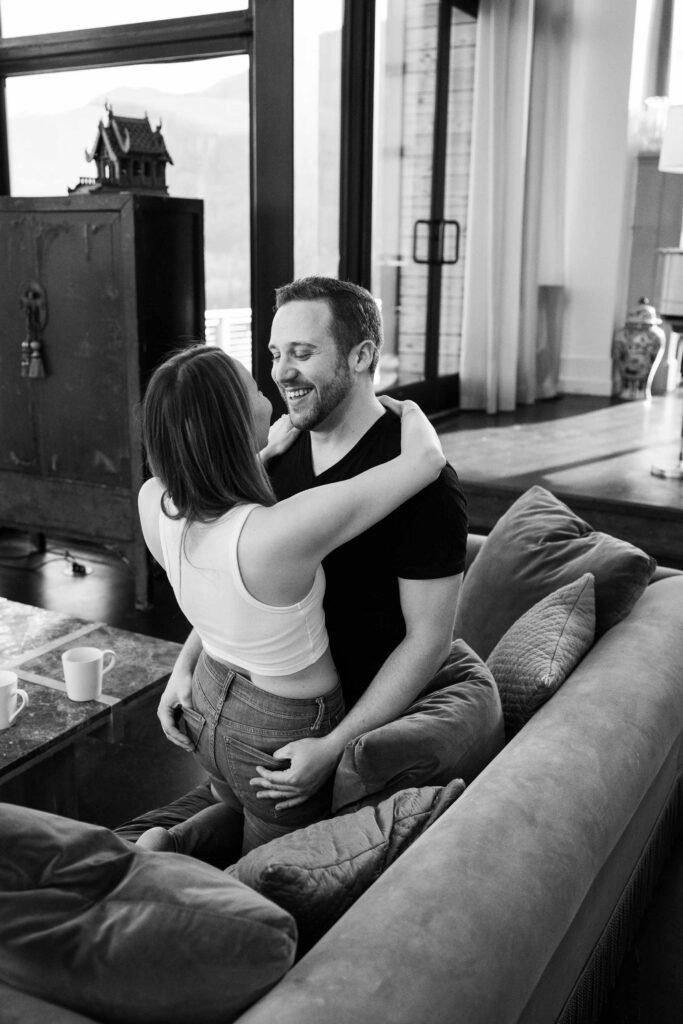 black and white photo of a couple smiling and cuddling on the couch