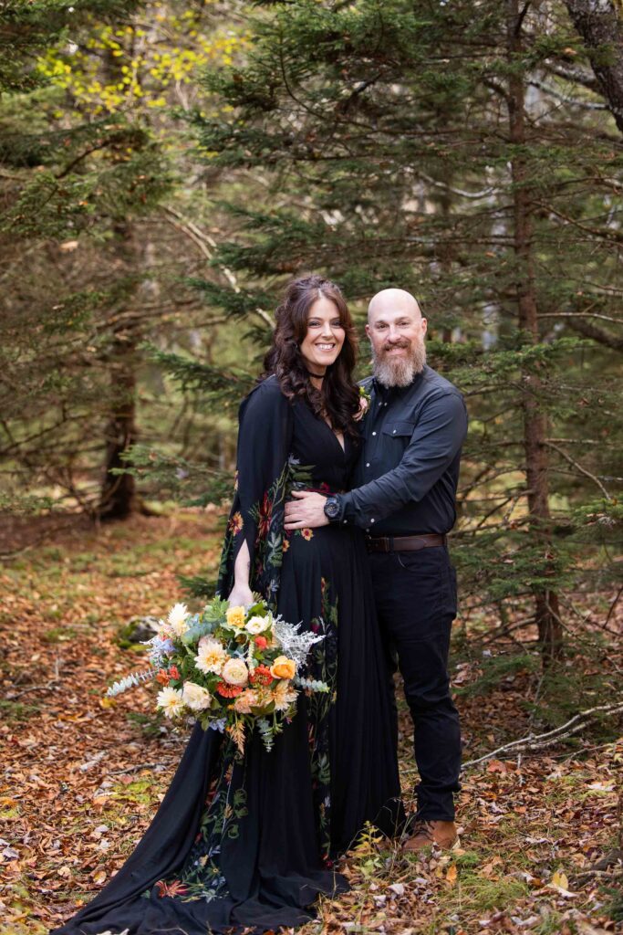 happy and smiling bride and groom in all black during their fall elopement at grayson highlands state park