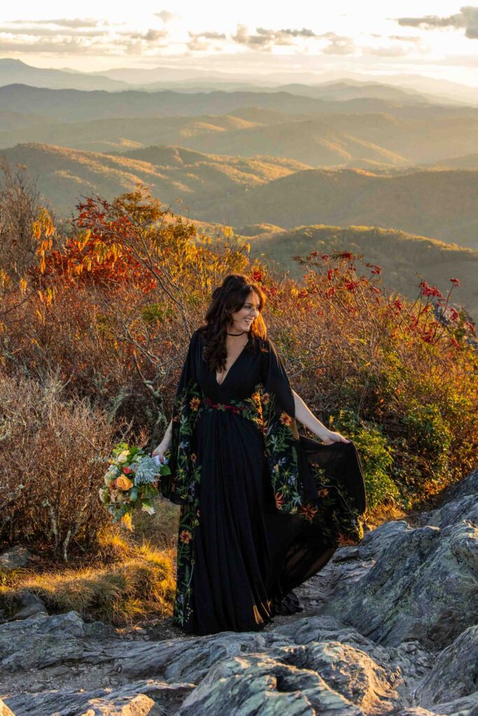 bride dances in the sunset wearing a floral embroidered black wedding dress during her elopement at the grayson highlands