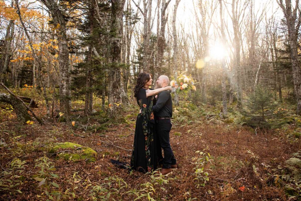 couple hiking to their elopement spot at grayson highlands state park in va during fall