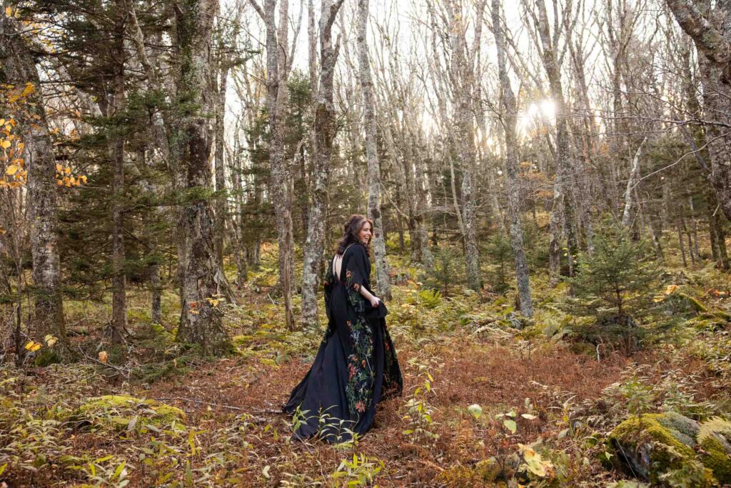 Bride in all black wedding gown walking through an enchanted forest during a Virginia Blue Ridge hiking elopement.