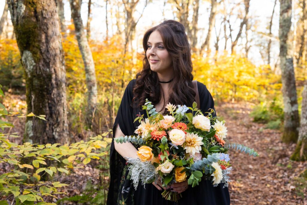 Bride wearing an embroidered floral black gown with fall-inspired bouquet during a Virginia Blue Ridge elopement.