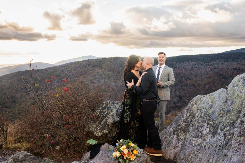 elopement first kiss with officiant on a grayson highlands mountain peak during the fall in virginia