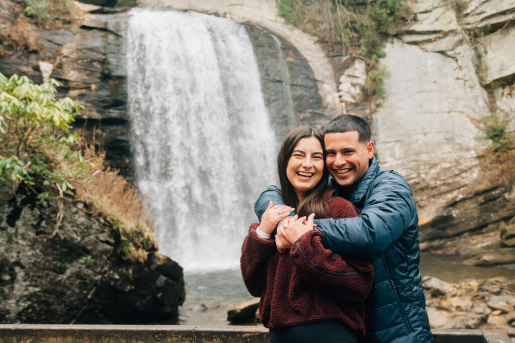 Romantic couple embracing during an engagement session at Looking Glass Falls in Pisgah National Forest, Brevard NC.