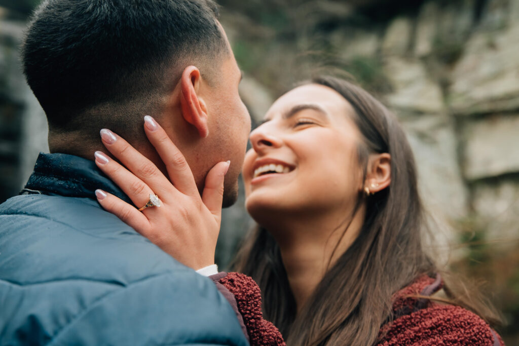 Close-up of engagement ring during a surprise proposal at Looking Glass Falls near Brevard, North Carolina, surrounded by forest and waterfall views.