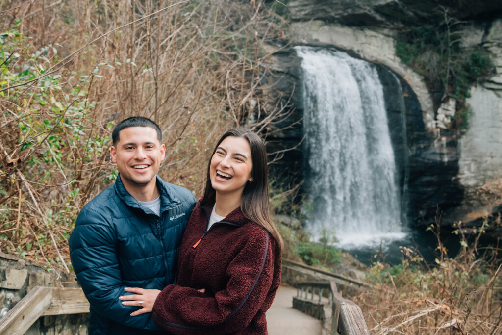 Romantic couple embracing during an engagement session at Looking Glass Falls in Pisgah National Forest, Brevard NC.