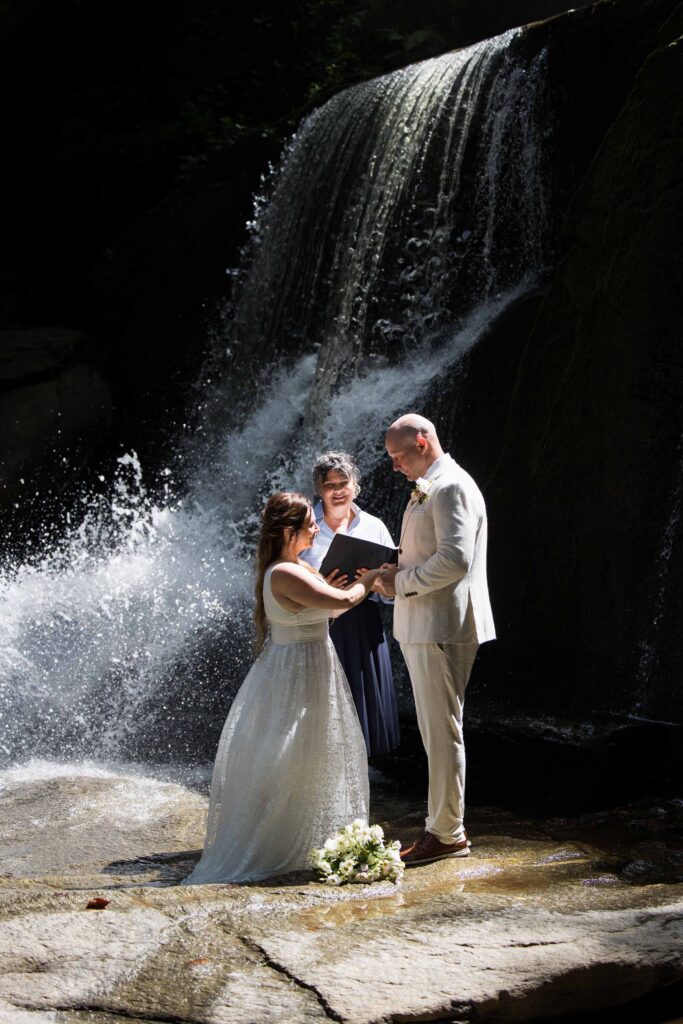 couple and officiant during wedding ceremony at a nc waterfall