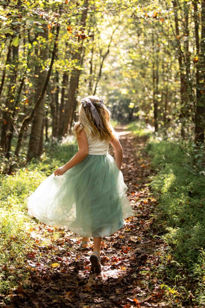 Flower girl running during Family elopement at Pilot Mountain State Park with couple and child by the Yadkin River