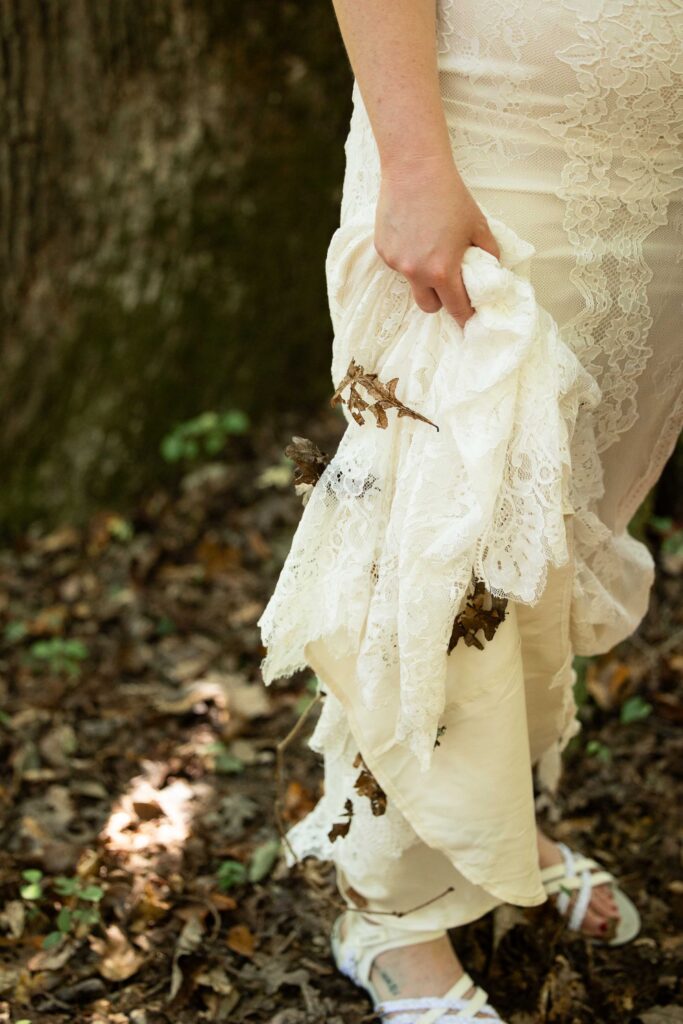Wedding details of a wedding dress with leaves stuck to it photographed during an all-inclusive elopement at Pilot Mountain
