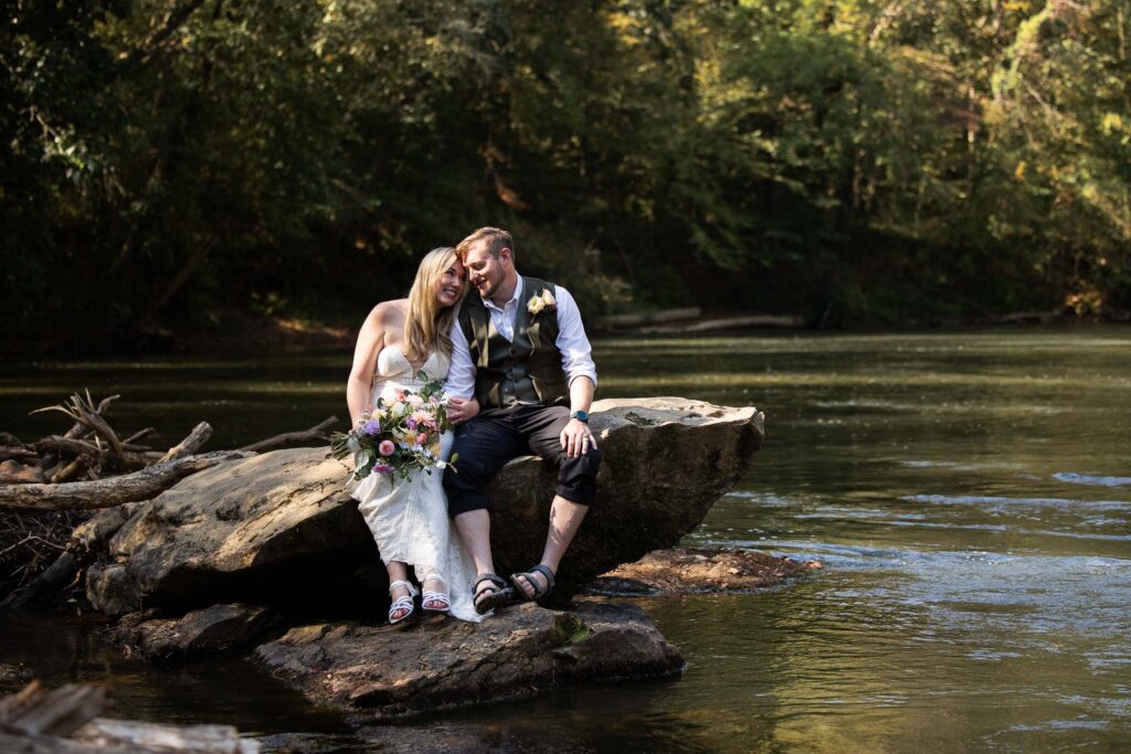 Outdoor elopement on a rock in the river at Pilot Mountain State Park along the Yadkin River near Winston-Salem