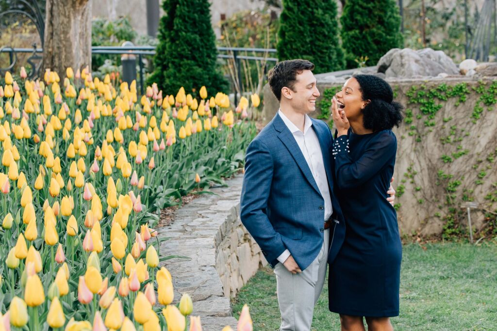 woman laughs and embraces her fiance after their proposal at the asheville arboretum