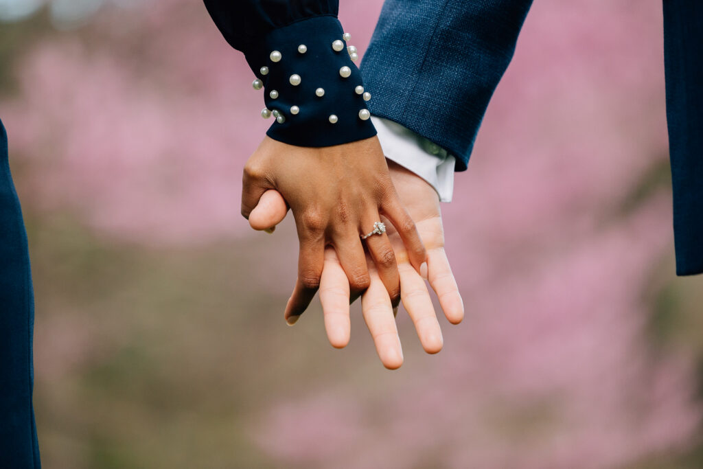 closeup of couple holding hands after their surprise proposal in asheville at the unc arboretum