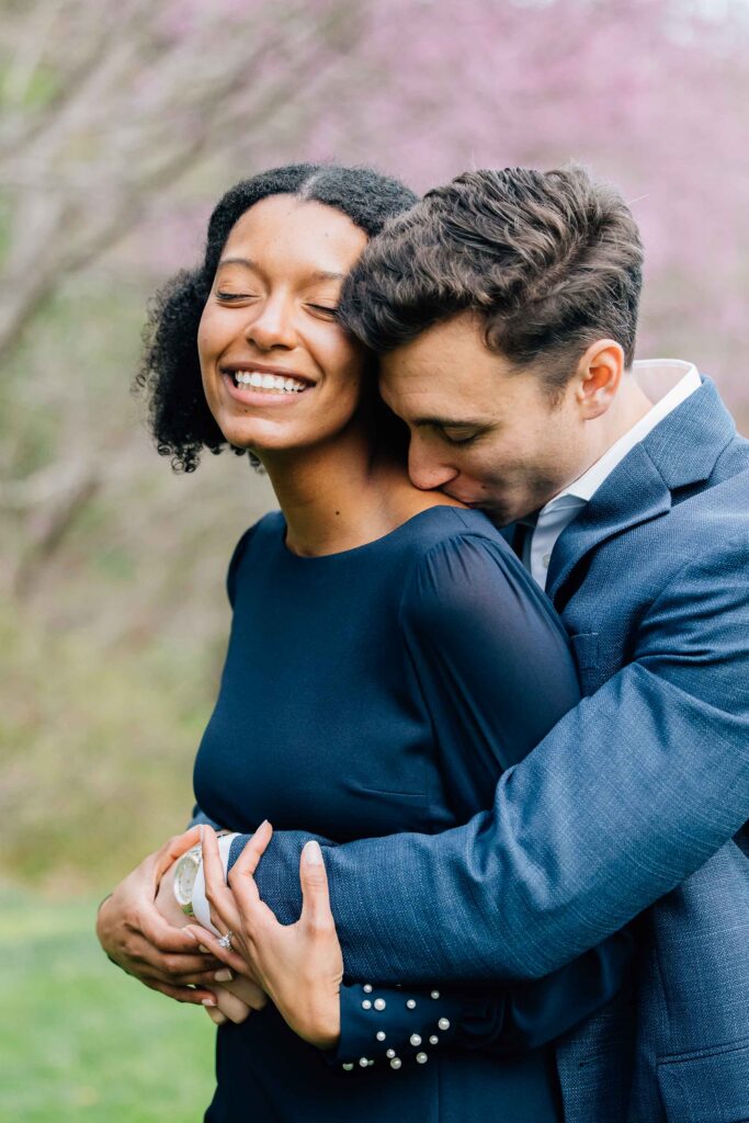 man kisses his fiancee's shoulder during their proposal session in asheville