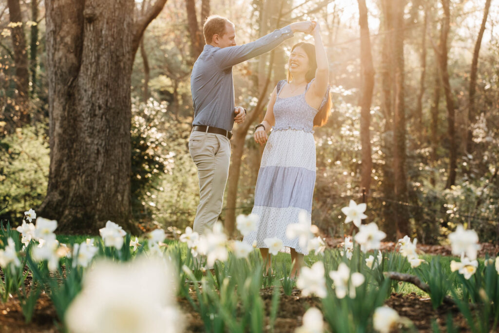 couple dances in the flowers after she said yes to his marriage proposal at the graylyn estate