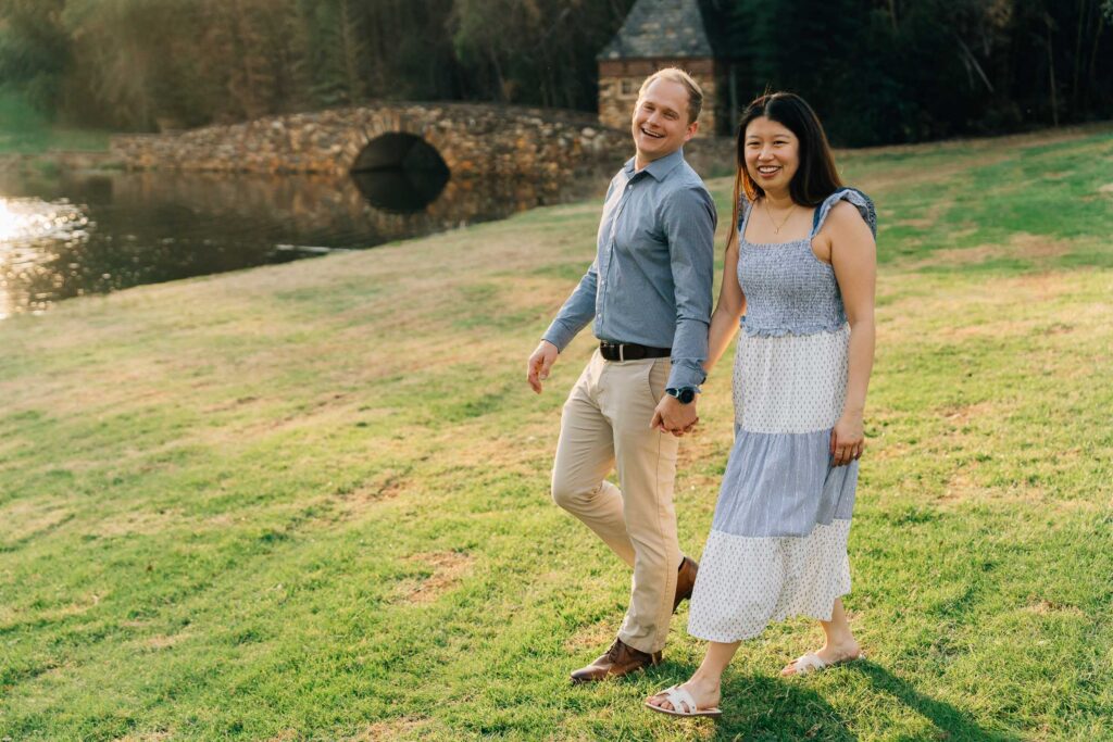 couple walks through the lawn in front of the bride after their graylyn estate marriage proposal