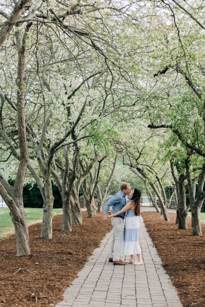 newly engaged couple dances under cherry blossoms at the graylyn estate in nc after their surprise proposal