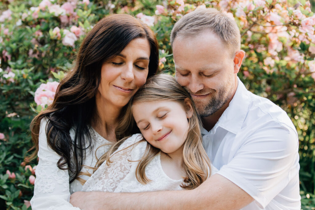 family cuddles together with their eyes closed in salisbury nc