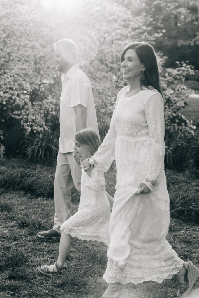 black and white photo of a family walking in hurley park in salisbury nc at golden hour