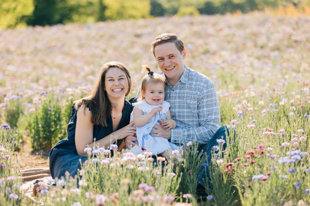 family sitting on a blanket at dogwood farms in belews creek, nc during a family photography session