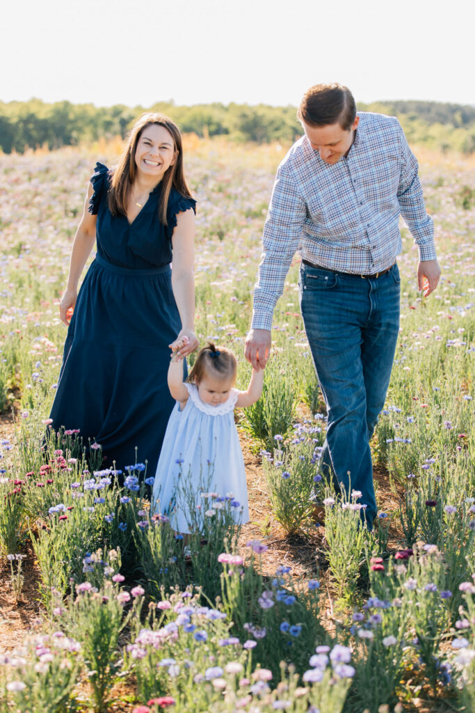 family walks through a wildflower field near winston-salem, nc