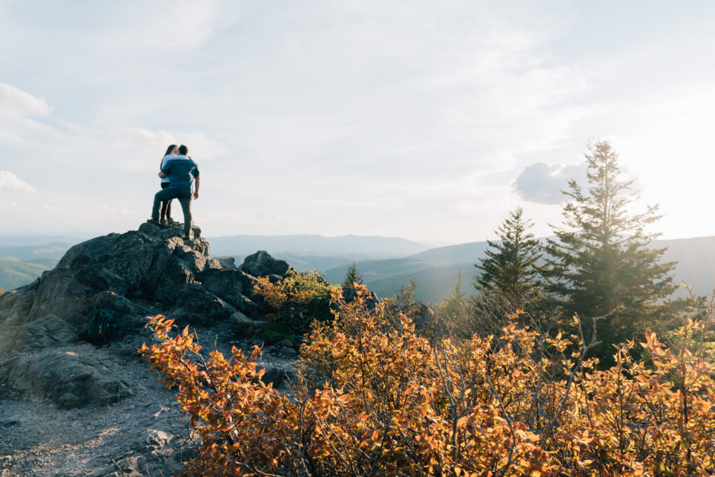 couple stands on top of Little Pinnacle, a hike in Grayson Highlands State Park, just before their surprise proposal