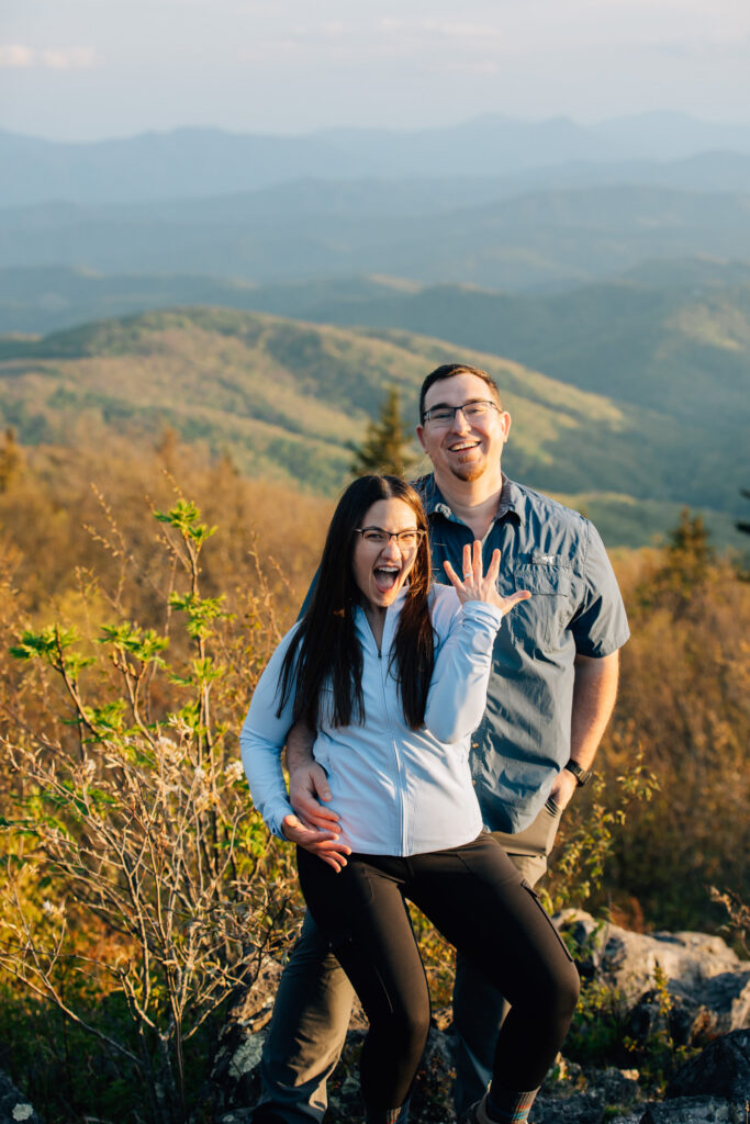 woman shows off her new engagement ring after her boyfriend proposed to her at grayson highlands state park on a hike