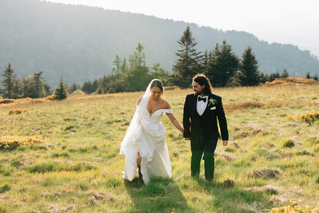 couple runs through a mountaintop meadow in the roan highlands during their elopement