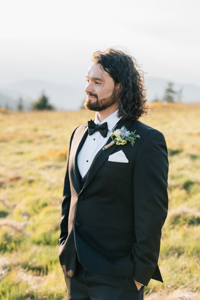 groom in a tux and black tie during his elopement at carver's gap