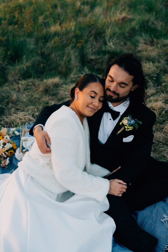 couple embraces with their eyes closed with the golden sun rays on their faces during their carver's gap elopement