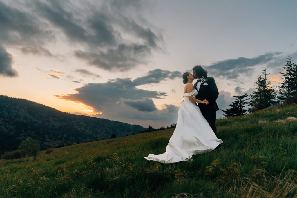 couple kisses during their sunset elopement in the roan highlands