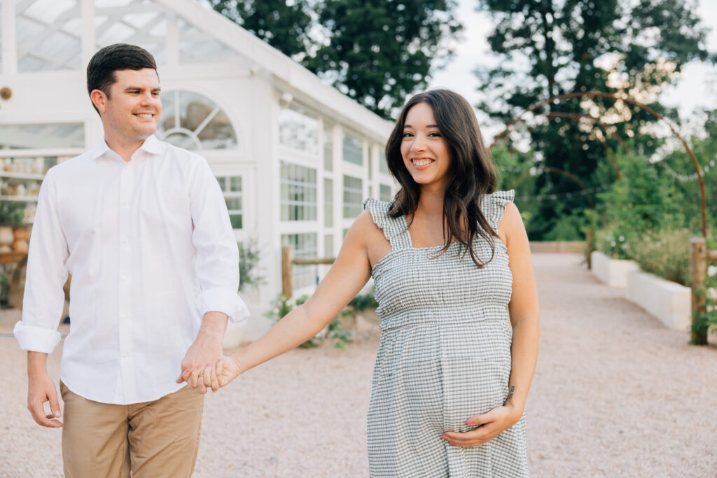 couple laughs during fleurish greenhouse maternity photos