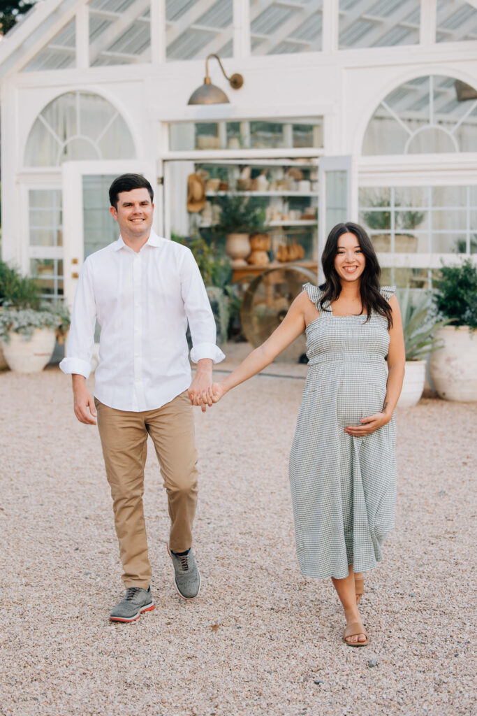 couple laughs during fleurish greenhouse maternity photos