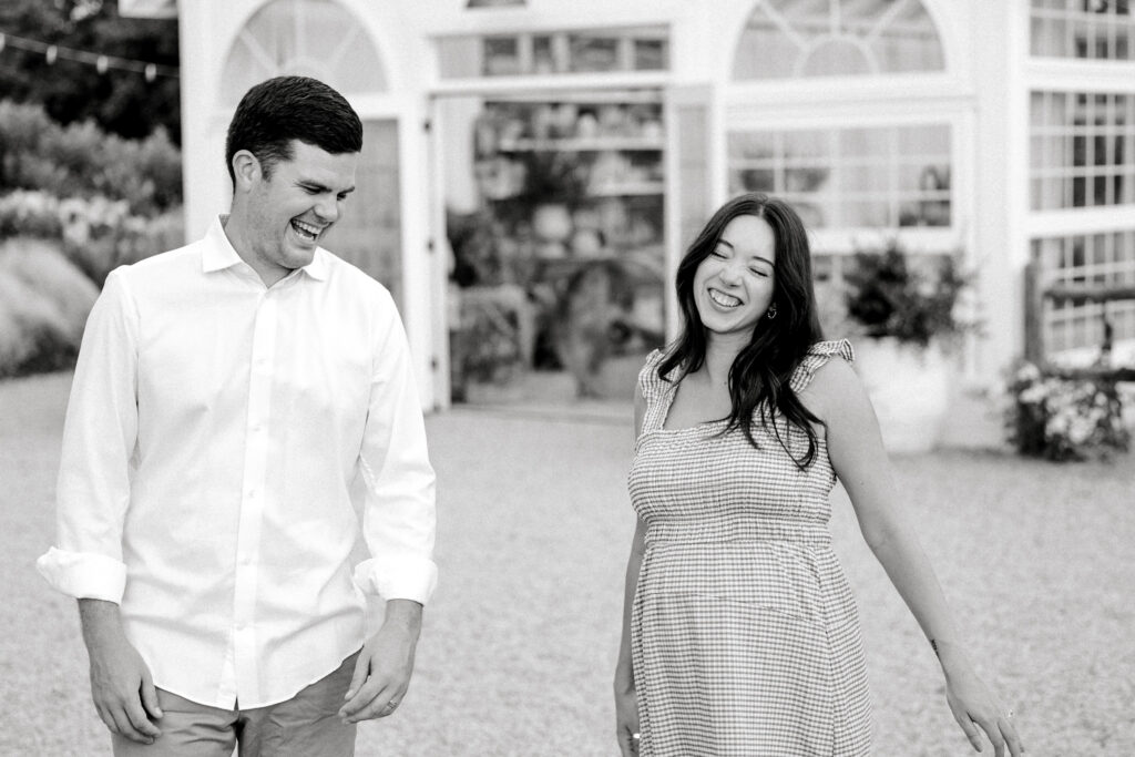 couple laughs during fleurish greenhouse maternity photos