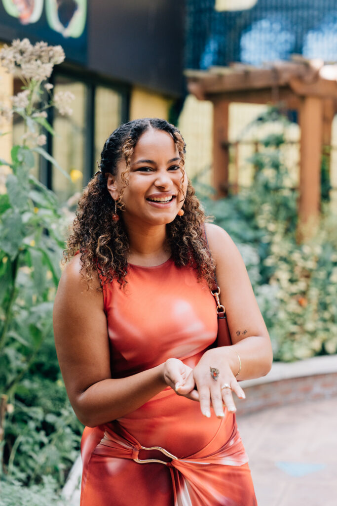 woman showing off her engagement ring with a butterfly sitting on her hand at the greensboro science center