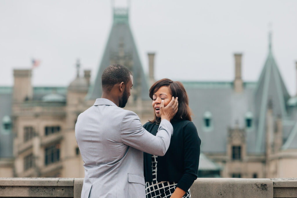 man wipes away tears from his fiancee's face right after his proposal at the biltmore estate