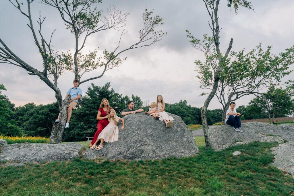 candid family photos of a family climbing rocks at doughton park on the blue ridge parkway in north carolina