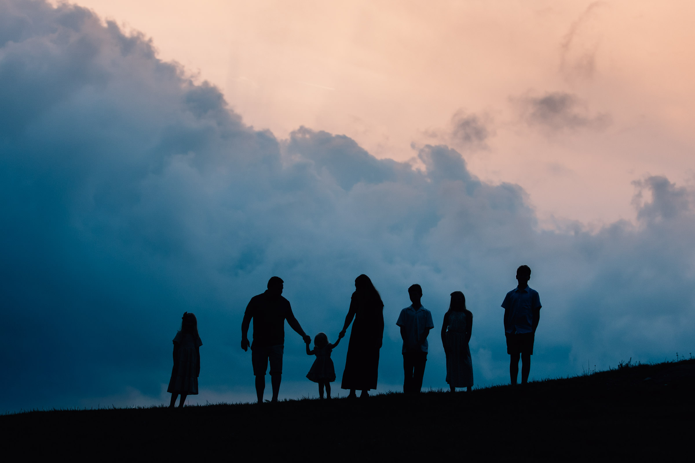 sunset silhouette of a family of 7 during a family photo session at doughton park on the blue ridge parkway