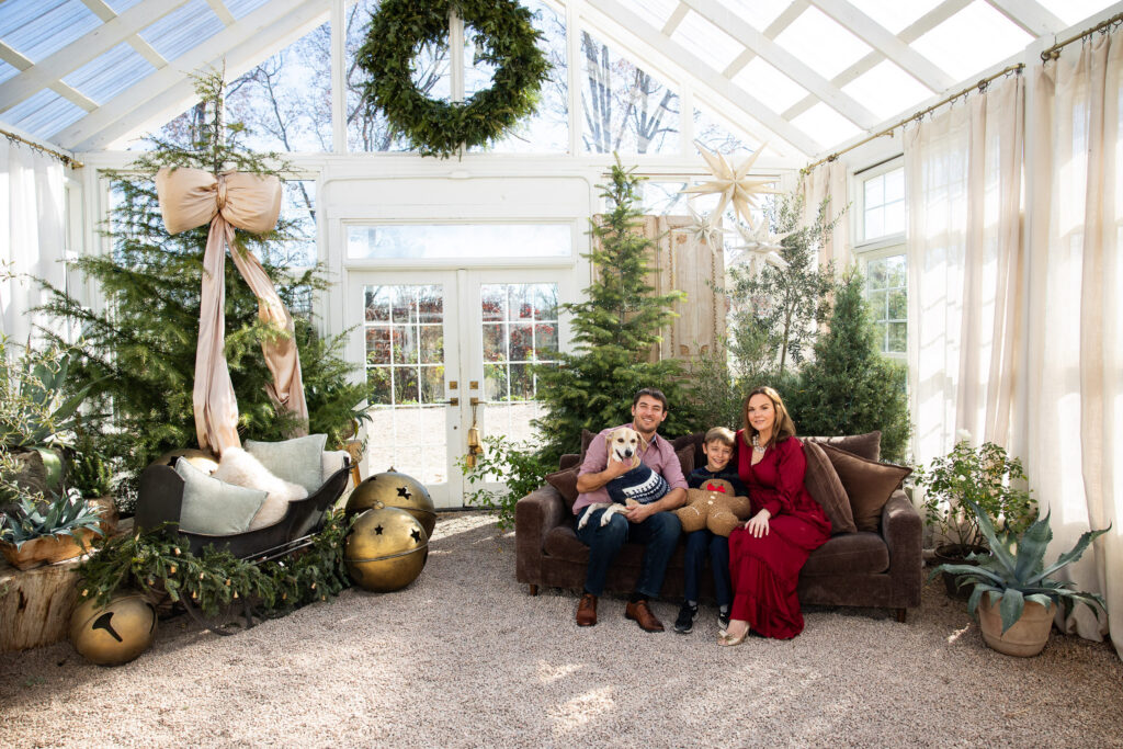 family sits on couch during christmas mini session at fleurish greenhouse in taylorsville, nc