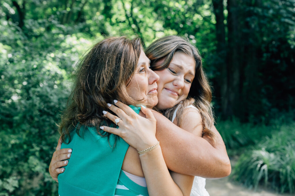 mom and daughter hug after her boyfriend proposed to her