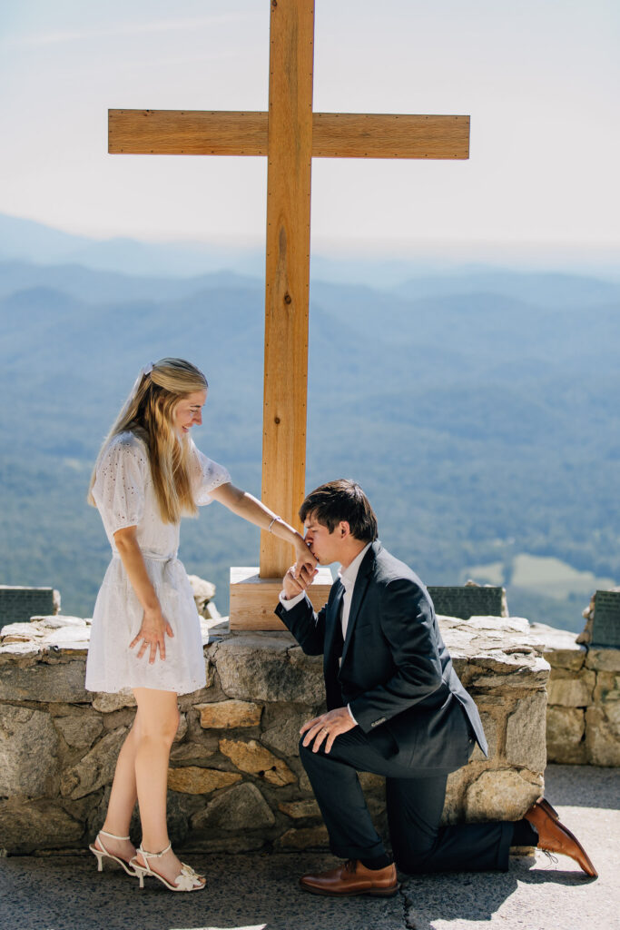 man kisses his girlfriend's hand during their surprise marriage proposal at fred w symmes chapel in sc